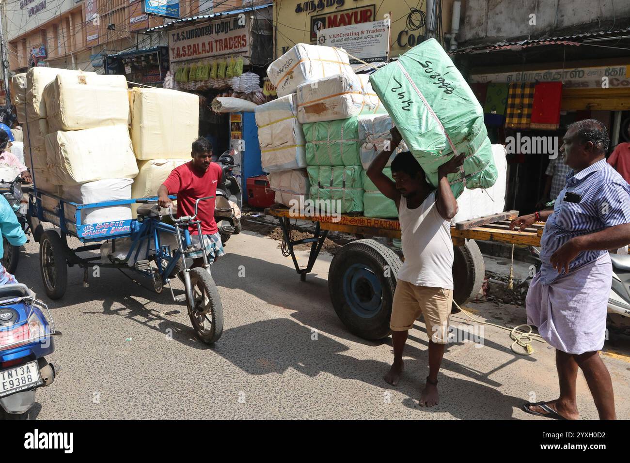 I coolie trasportano merci e scaricano merci nel distretto George Town di Chennai, Tamil Nadu, India Foto Stock