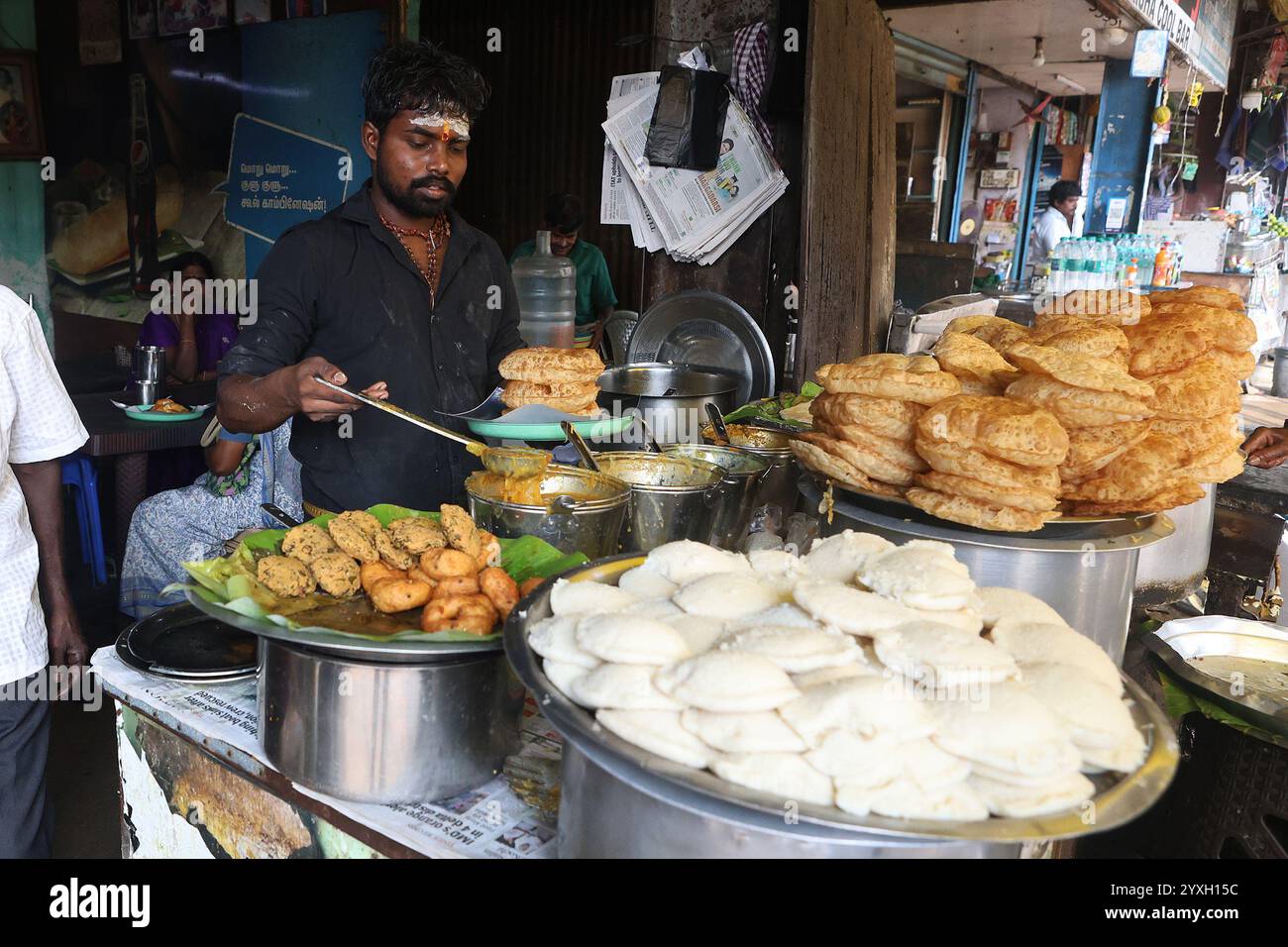 Venditore che serve tiffin da una bancarella di cibo nel distretto George Town di Chennai, Tamil Nadu, India Foto Stock