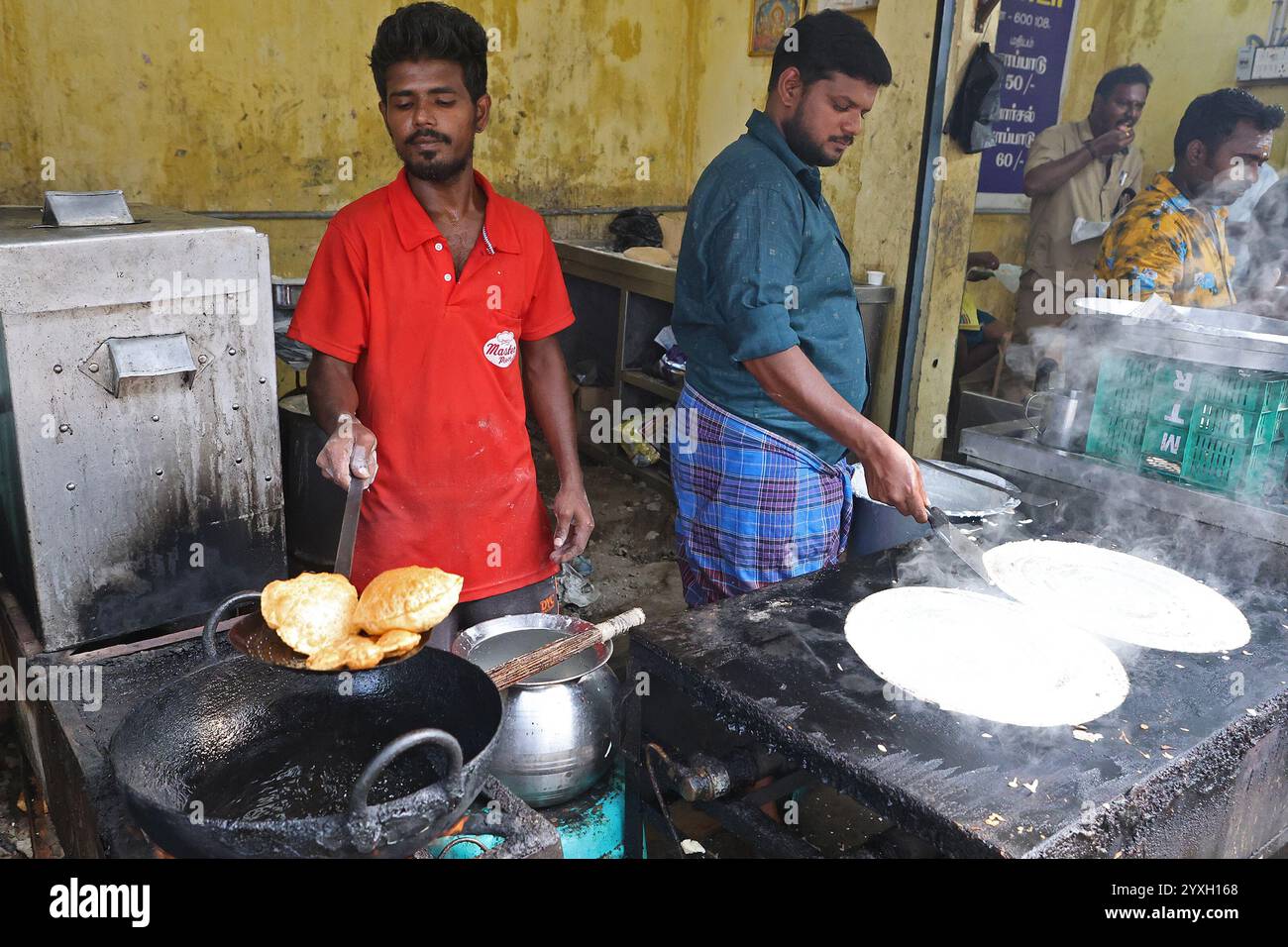 Venditori ambulanti che cucinano puri e masala dosa in un chiosco di cibo nel quartiere George Town di Chennai, Tamil Nadu, India Foto Stock