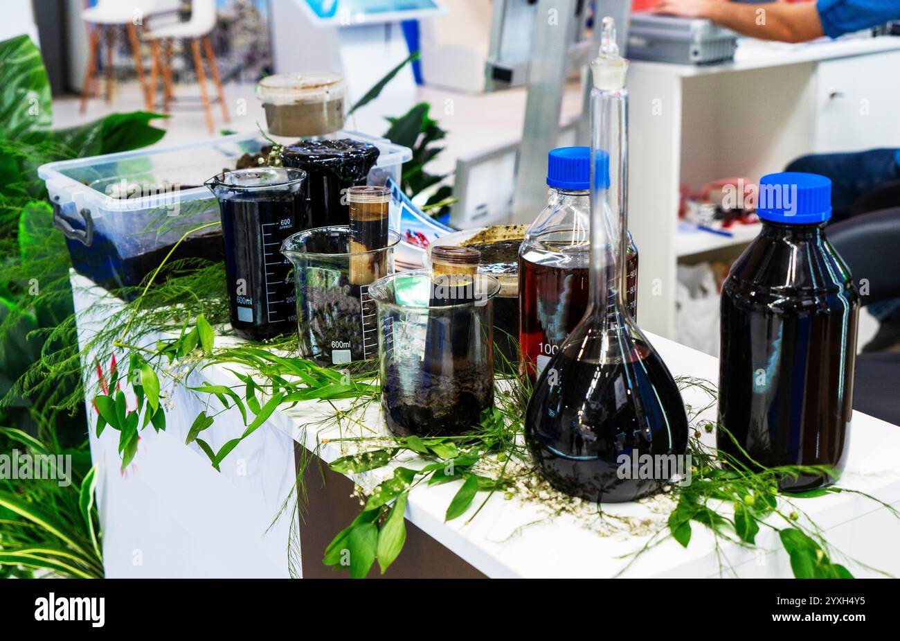 Vari prodotti di scarto, olio, olio combustibile, benzina in contenitori di plastica e vetro alla fiera Foto Stock