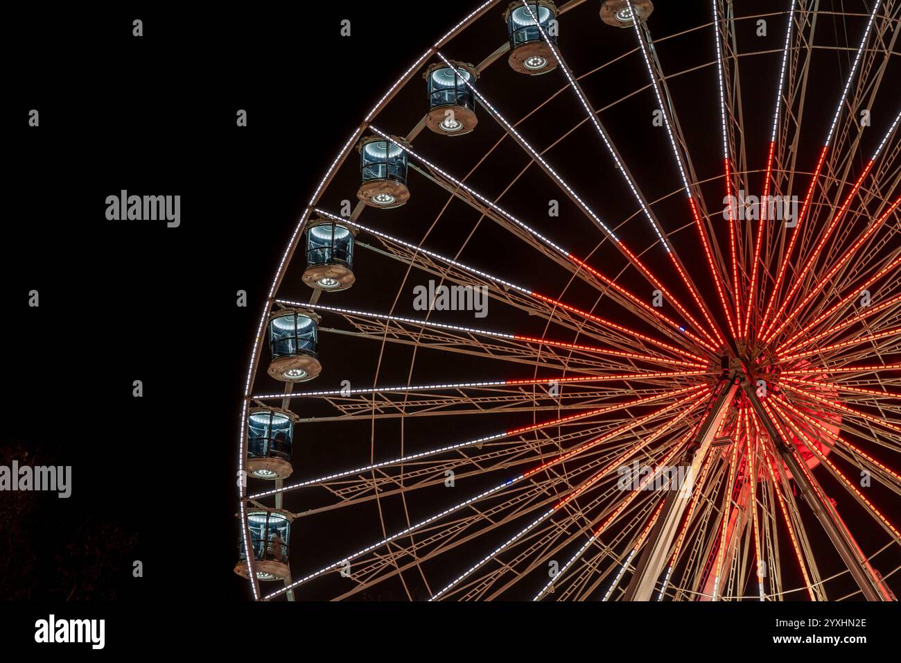 Vista parziale di una ruota panoramica illuminata durante la notte al mercatino di Natale di Oslo. Atmosfera festosa e magica. Foto Stock