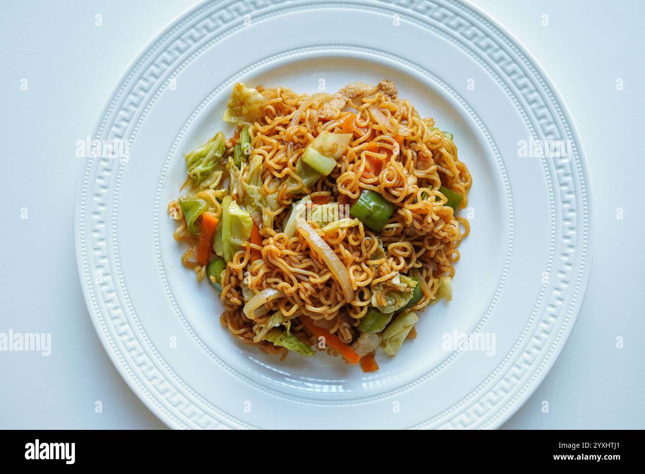 Tagliatelle yakisoba su un tavolo bianco、Vista dall'alto、tagliatelle saltate tradizionali giapponesi con carne, verdure e una salsa speciale Foto Stock