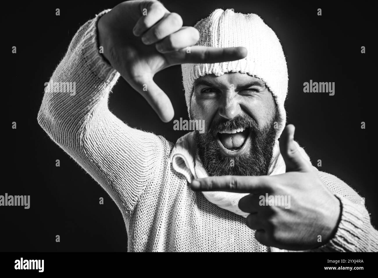 Bell'uomo barbuto che crea cornice con le dita. Foto di selfie immaginarie. Insegna fotografica. Un ragazzo creativo felice mostra che il gesto fotografico rende la fotocamera f Foto Stock
