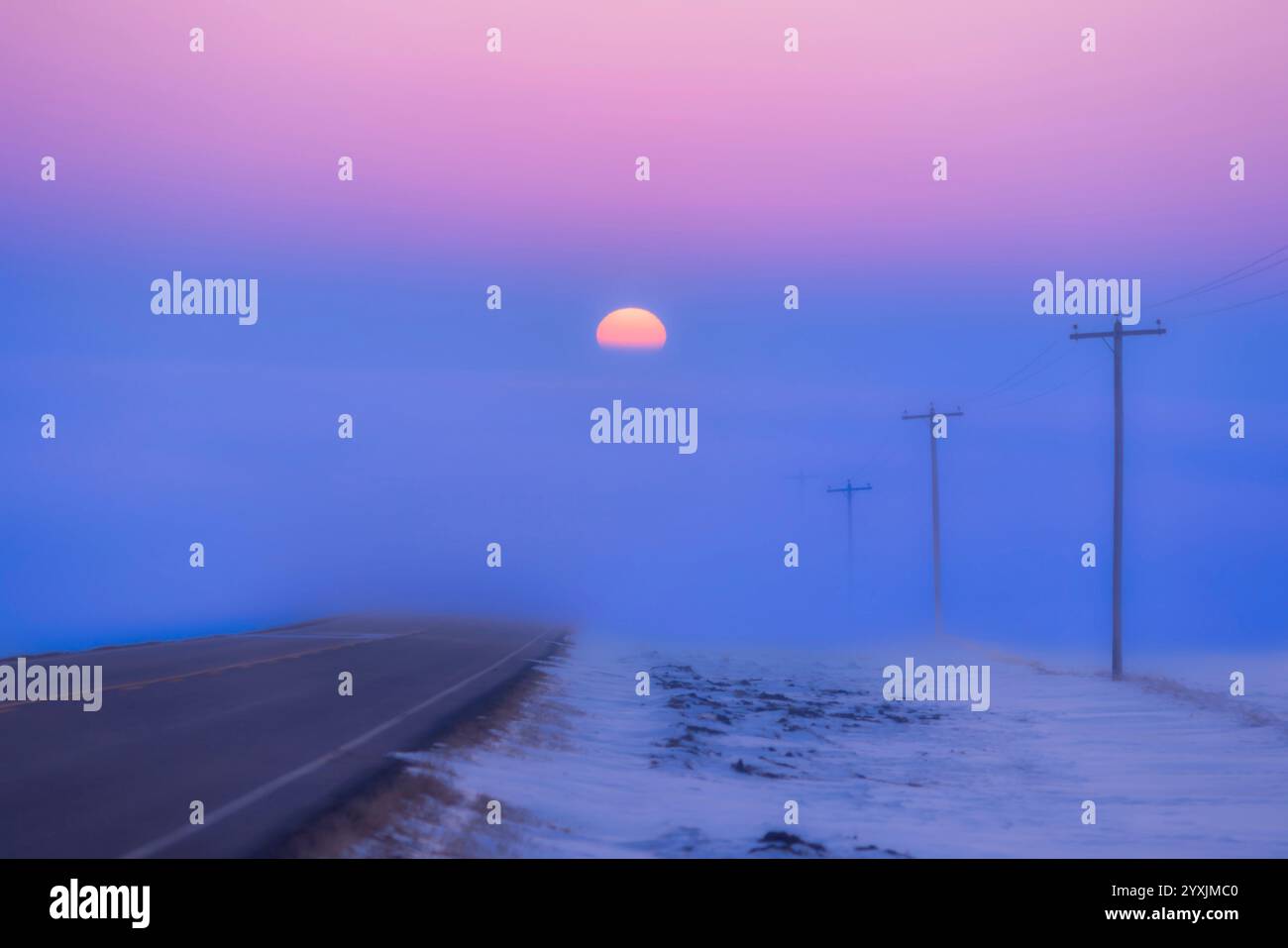 The Setting Sun che scende in un banco nebbia sull'autostrada 561 ad Alberta, Canada. Foto Stock