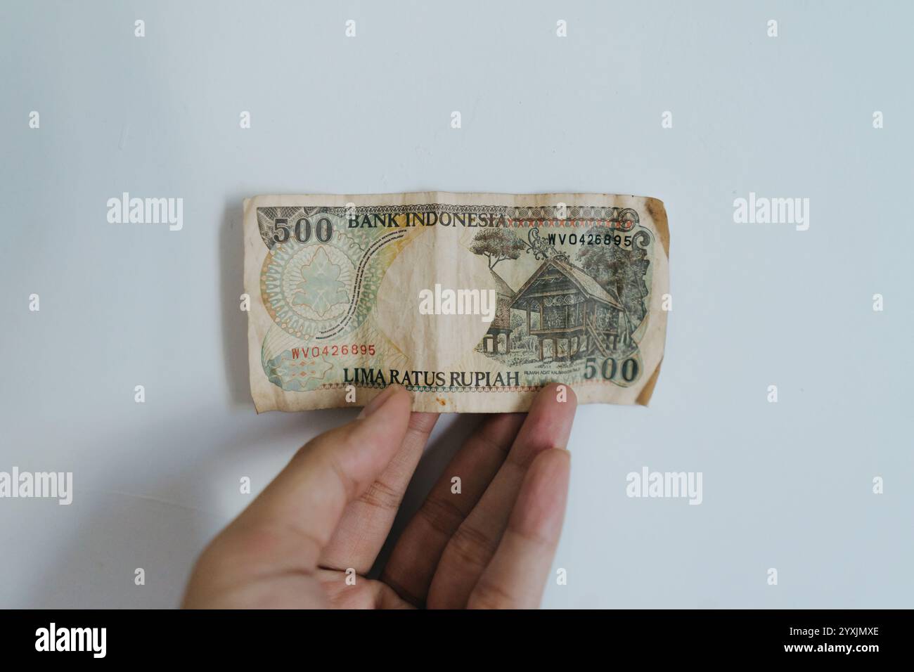 A mano che regge una vecchia banconota da rupia di valore nominale di 500 Foto Stock