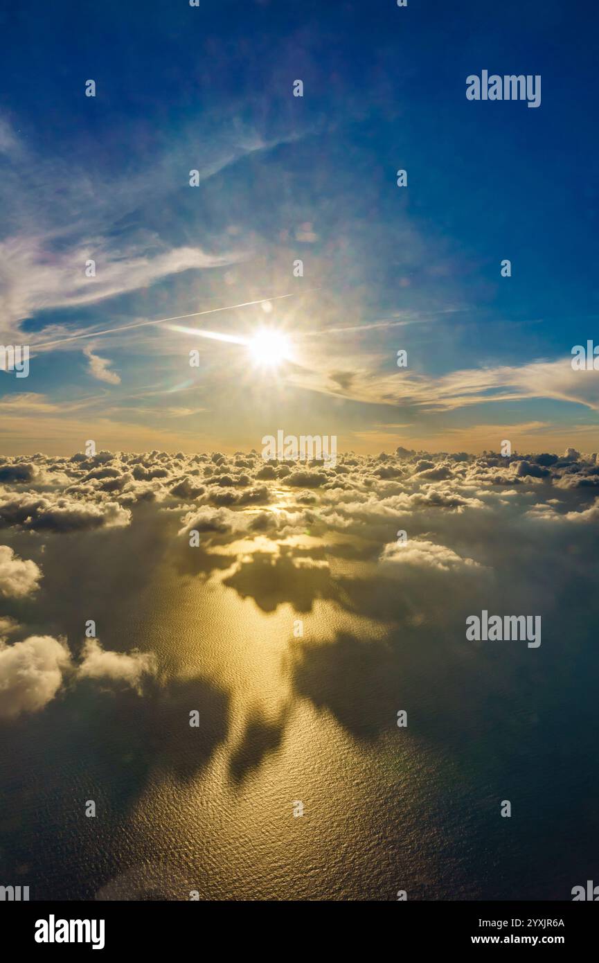 Il sole splende sull'acqua, creando un bel riflesso. Il cielo è pieno di nuvole, donando alla scena un'atmosfera serena e tranquilla Foto Stock
