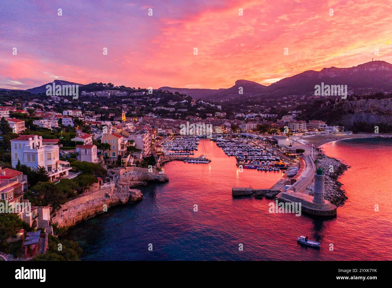 Port De Cassis, Uno splendido porto all'alba, presenta cieli vibranti su una pittoresca cittadina costiera mediterranea. Foto Stock