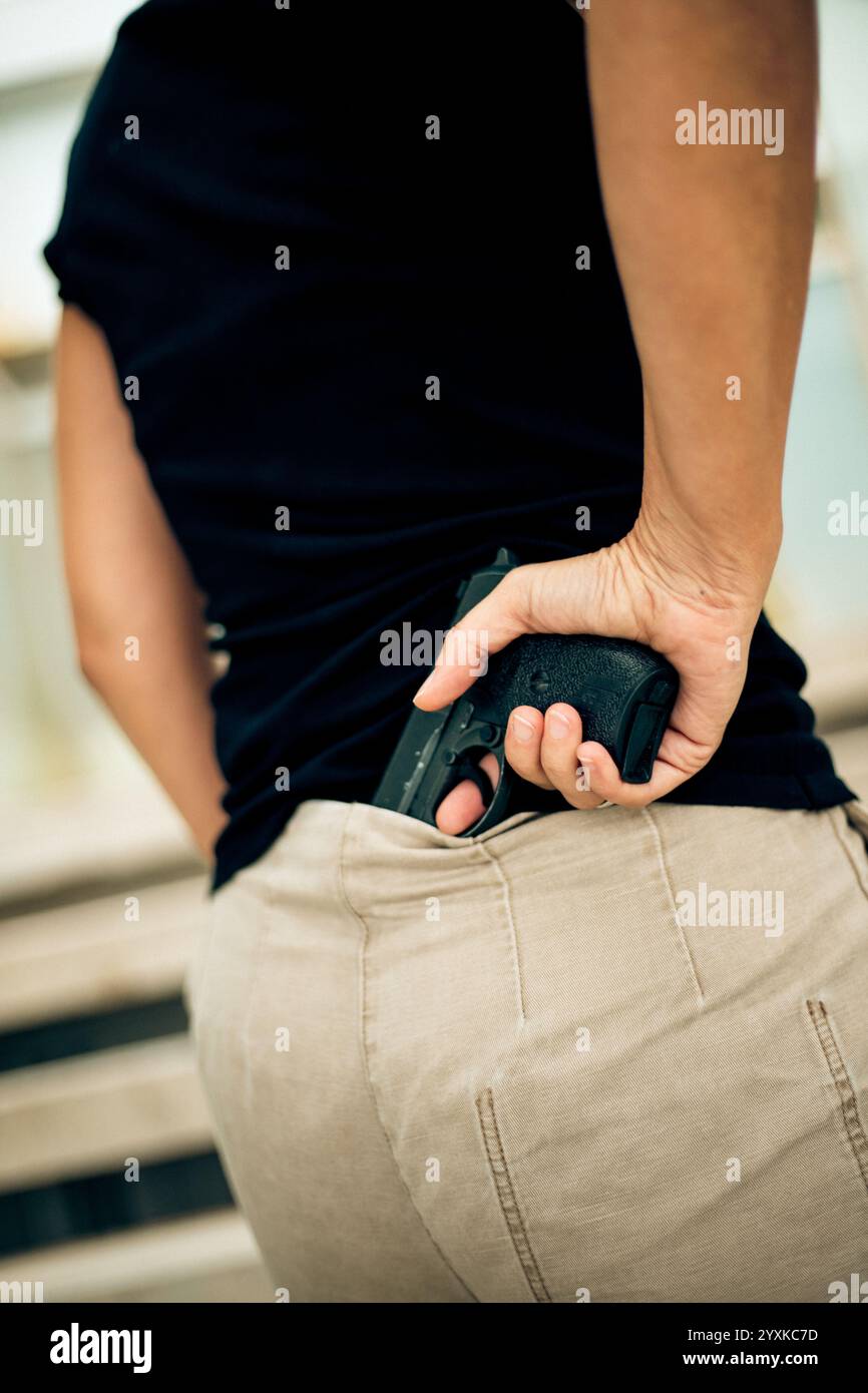 DONNA CON UNA PISTOLA, VISTA POSTERIORE Foto Stock