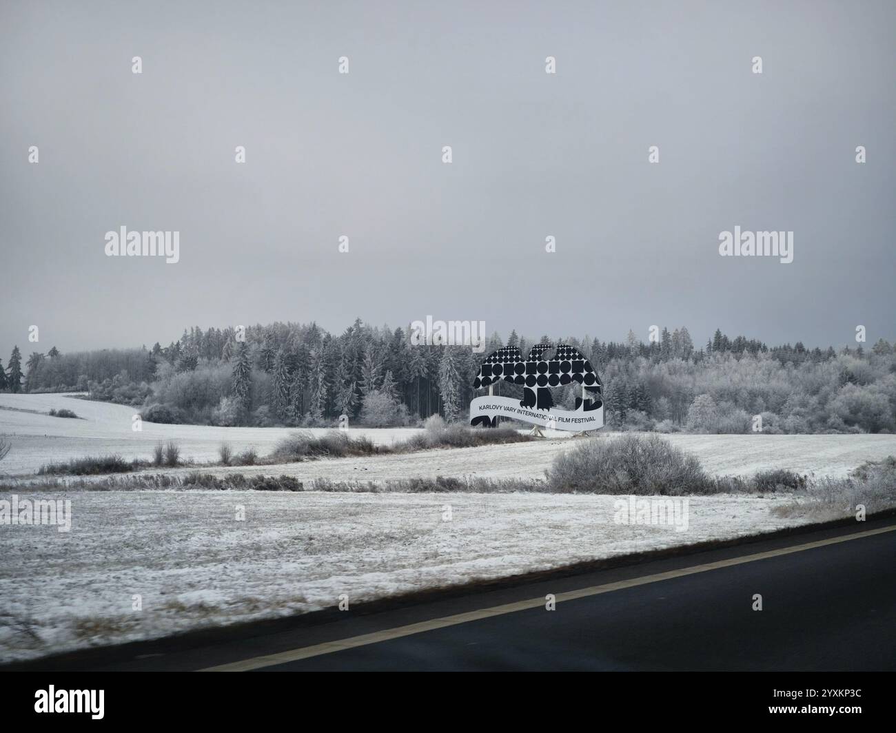 Karlovy Vary, repubblica Ceca - 14 dicembre 2024: Cartellone del festival internazionale del cinema di Karlovy Vary Mattoni in un paesaggio innevato Foto Stock