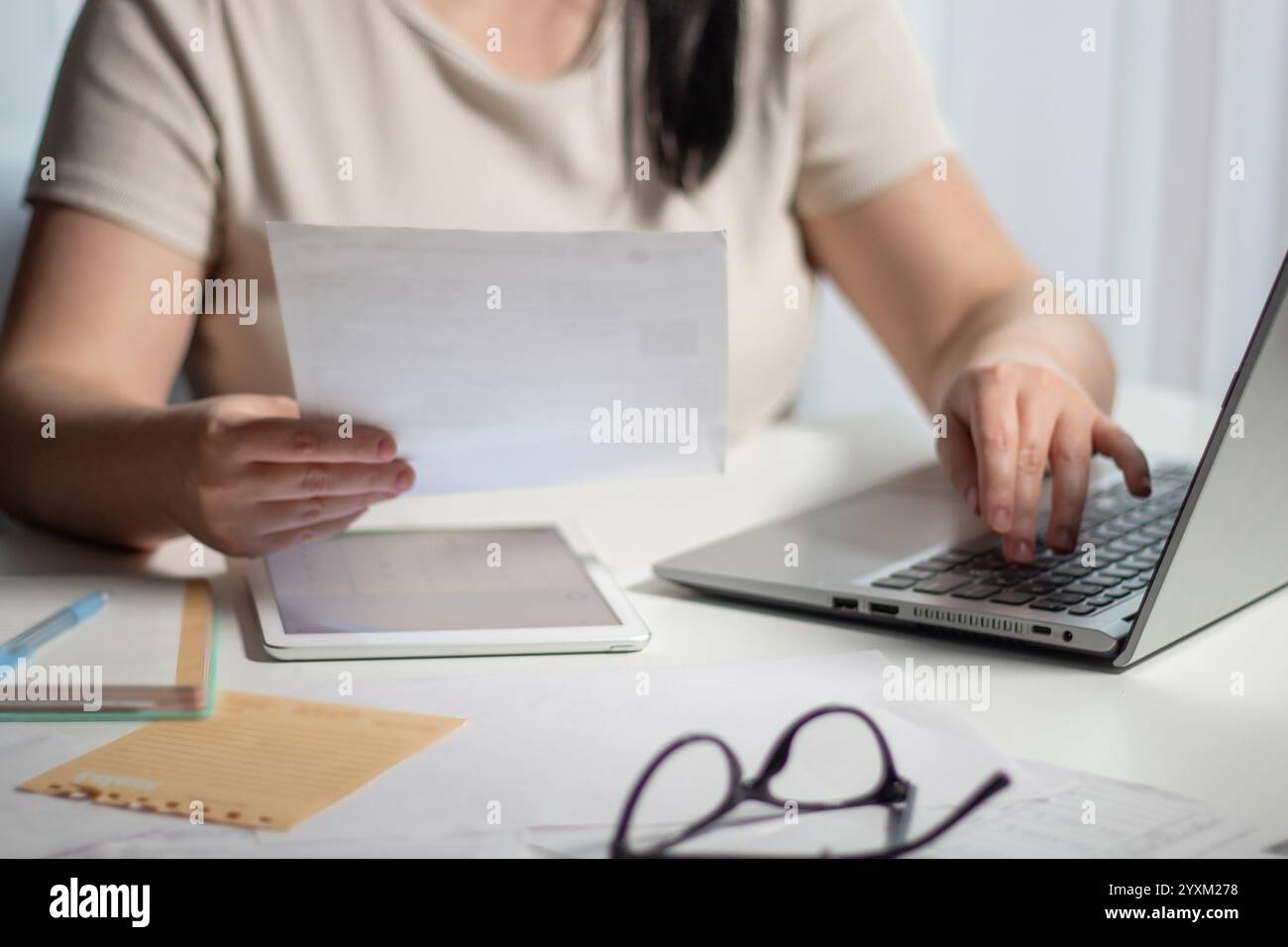 Donna che calcola il budget per il business online. Analizza i documenti finanziari. Concetto di lavoro remoto da casa Foto Stock