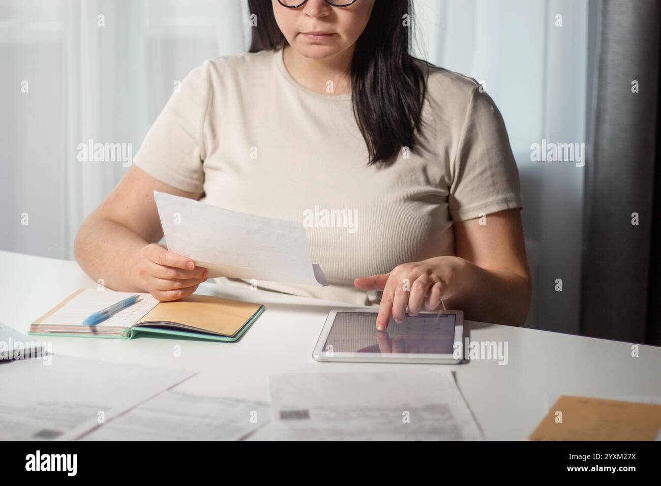 Donna che calcola il budget per il business online. Analizza i documenti finanziari. Concetto di lavoro remoto da casa Foto Stock