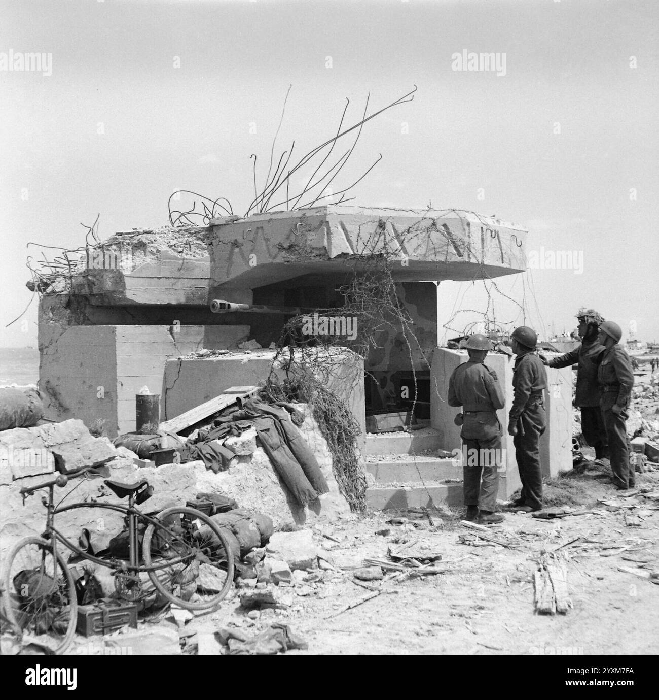 Le truppe ispezionano un cannone tedesco da 50 mm fuori uso nella sua collocazione a Gold Beach - Midgley (Sgt), No 5 Army Film & Photographic Unit, D-Day 6 giugno 1944 Foto Stock