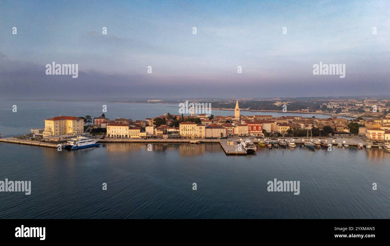 Splendida vista aerea del porticciolo di Poreč al crepuscolo, che mette in risalto l'architettura storica del lungomare della città e le calme acque dell'Adriatico. Foto Stock