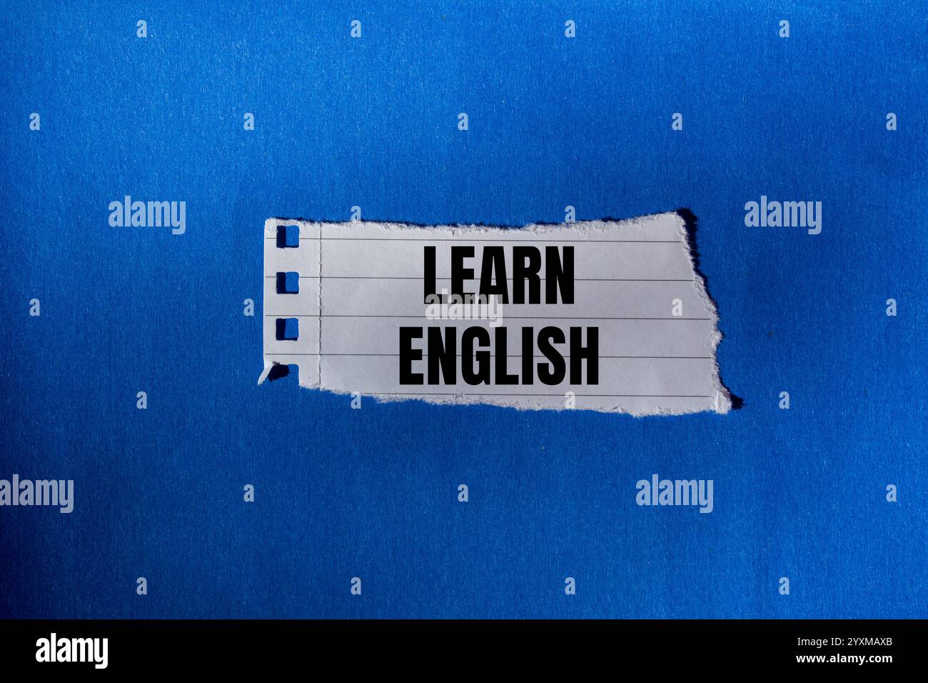 Impara il messaggio in inglese scritto su un pezzo di carta strappato con sfondo blu. Simbolo Impara l'inglese concettuale. Copia spazio. Foto Stock