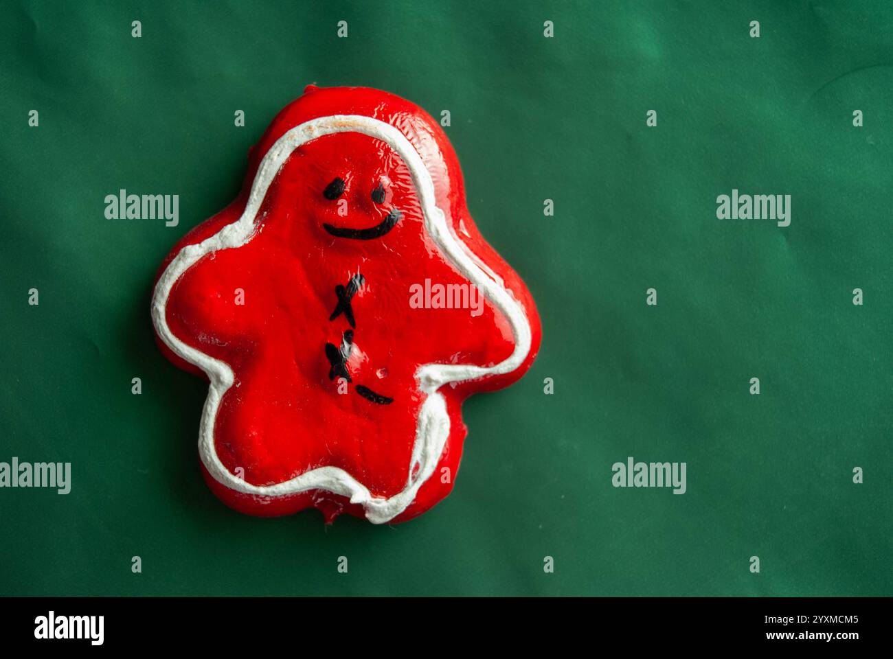 Biscotto decorativo rosso su sfondo verde con rami di pino. Foto Stock