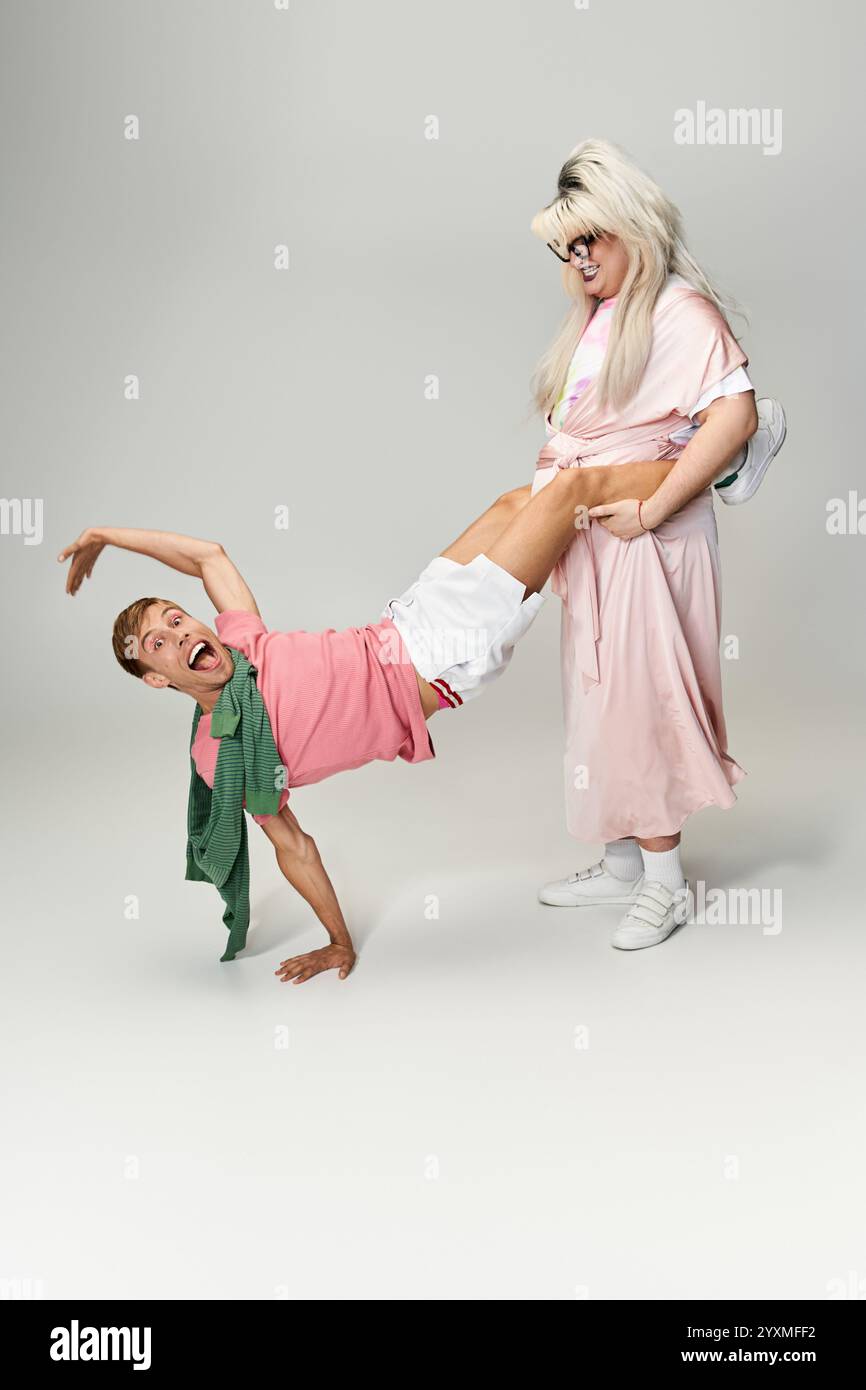 Due persone dinamiche si impegnano in una danza divertente ed energica, mostrando gioia e creatività queer. Foto Stock Due persone dinamiche si impegnano in una danza divertente ed energica, mostrando gioia e creatività queer. Foto Stock