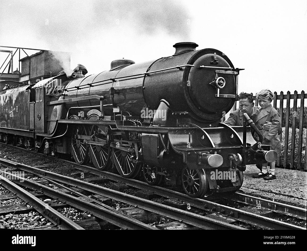 Padre mostra a sua figlia il funzionamento di una località a vapore sulla Romney, Hythe and Dymchurch Railway, Kent. 1950 anni Foto Stock