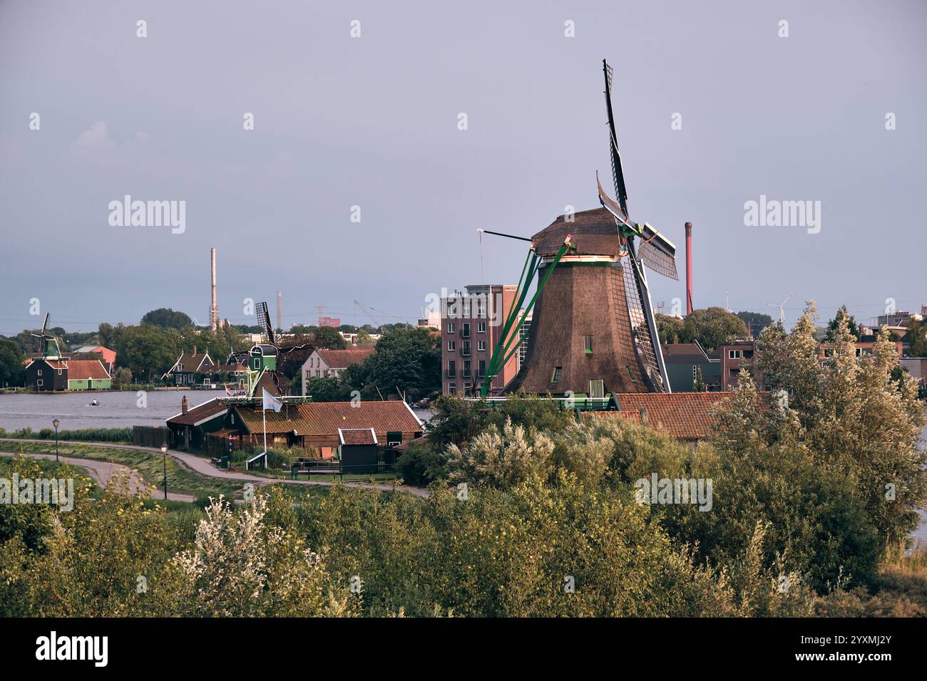 Vista panoramica di Zaanse Schans con lo storico mulino a vento De Bonte Hen, che mostra il patrimonio olandese, i paesaggi verdi e l'architettura iconica al tramonto, con Foto Stock