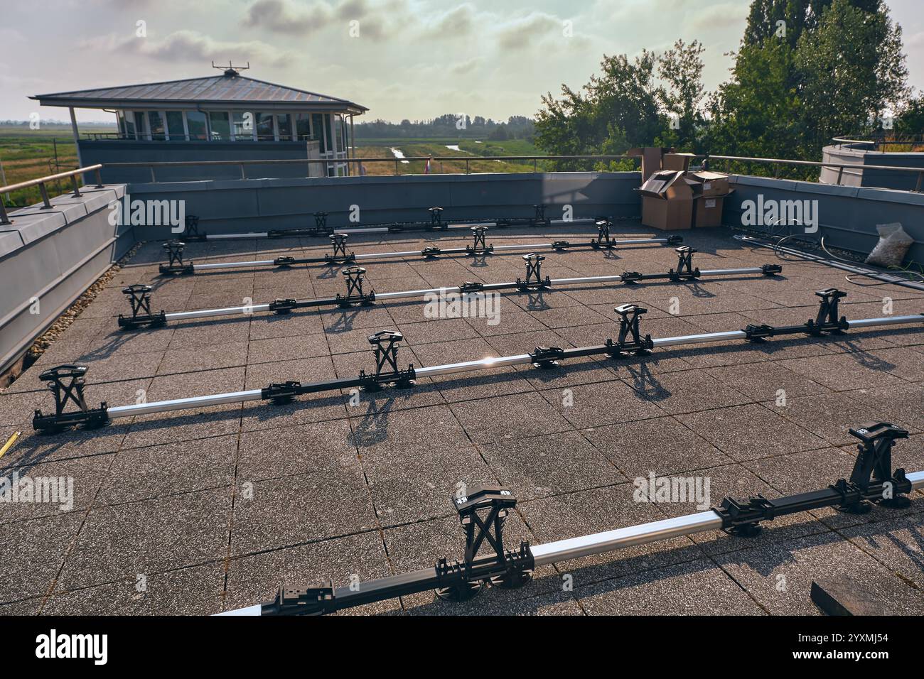 Terrazza sul tetto in costruzione con telai di montaggio a pannelli solari e mattoni per zavorra, che mette in mostra la tecnologia dell'energia pulita in un moderno ambiente urbano Foto Stock