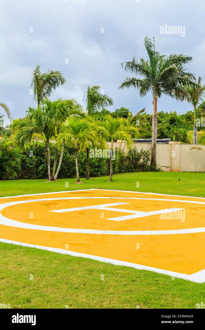 Un cerchio giallo e bianco con la lettera H. Il cerchio è su un campo verde Foto Stock