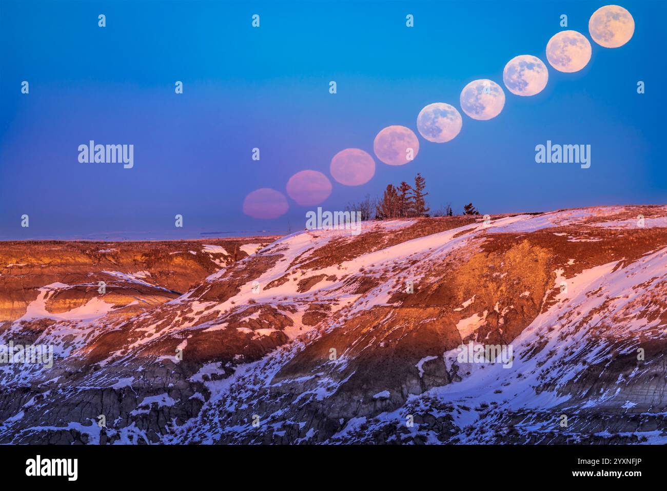 La luna piena che sorge sulle calanchi dell'Horseshoe Canyon in Alberta, Canada. Foto Stock