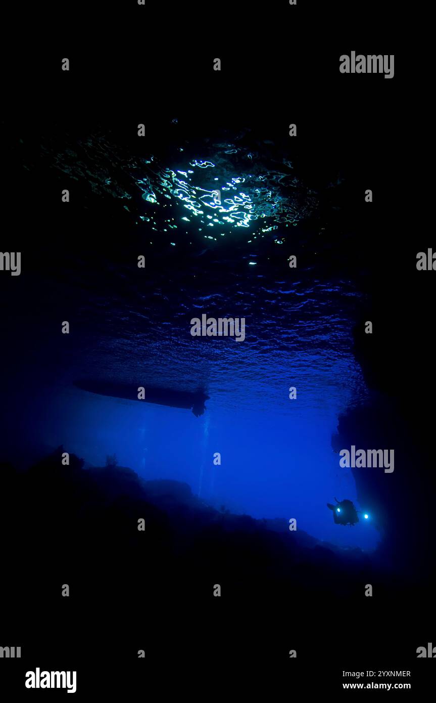 Tuffati con la fiaccolata che entra in una grotta a Christmas Island, Australia. Foto Stock