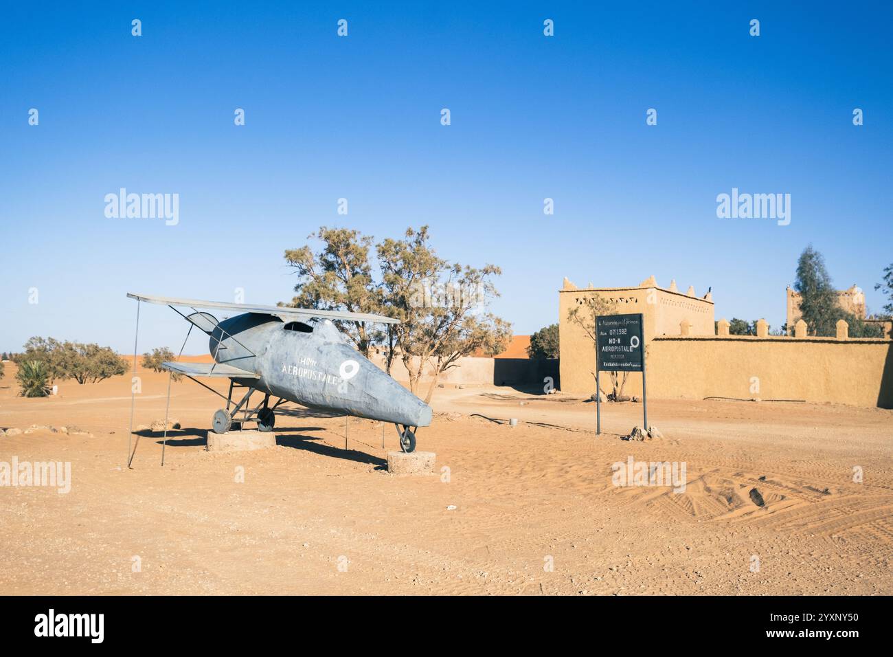 Ingresso di un hotel o riad nel deserto del Sahara nella regione di Merzouga, Marocco. All'ingresso il piccolo aereo che è stato utilizzato per le riprese del Foto Stock
