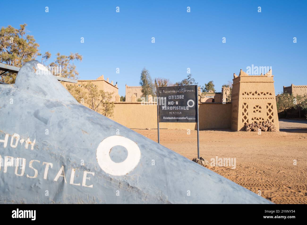 Dettaglio dell'ingresso di un hotel o riad nel deserto del Sahara nella regione di Merzouga, Marocco. All'ingresso il piccolo aereo che è stato utilizzato nella f Foto Stock