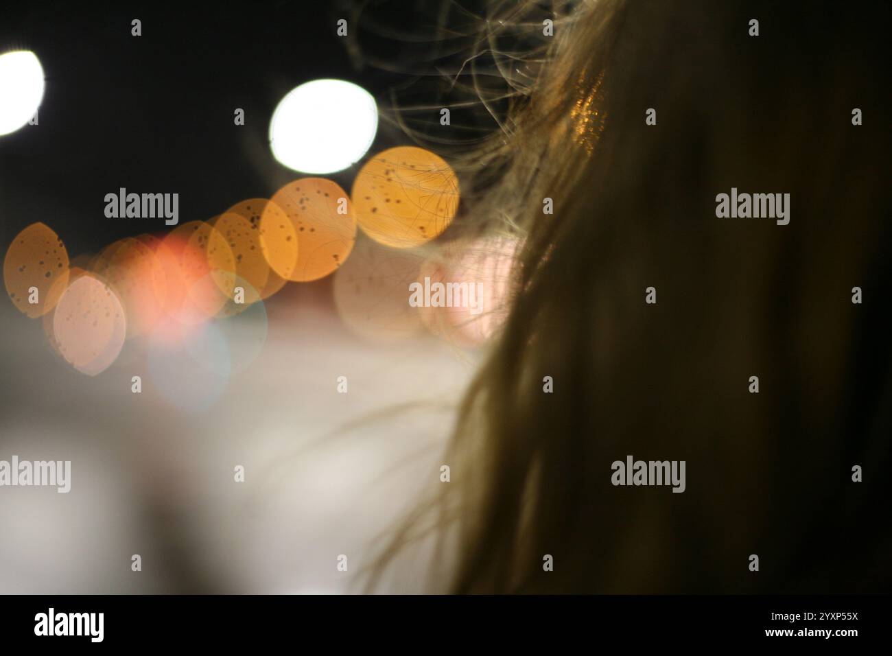 Una foto sfocata dei capelli di una donna con uno sfondo sfocato. La foto ha una qualità onirica ed eterea, come se fosse stata scattata in un sogno o in una fantasia Foto Stock