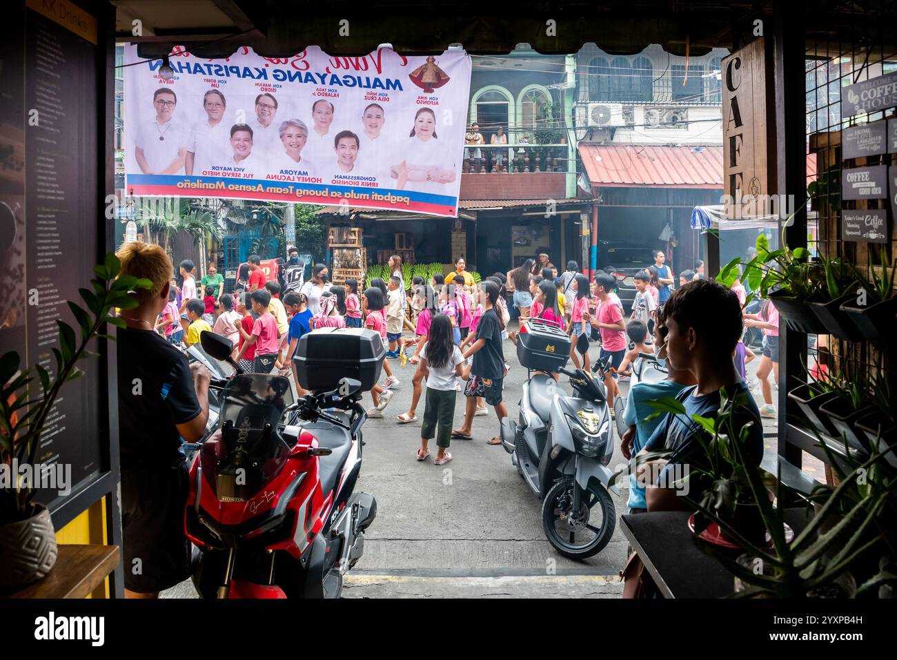Una parata religiosa cattolica passa davanti a una casa durante una parata annuale nel distretto tondo di Manila, nelle Filippine. Foto Stock