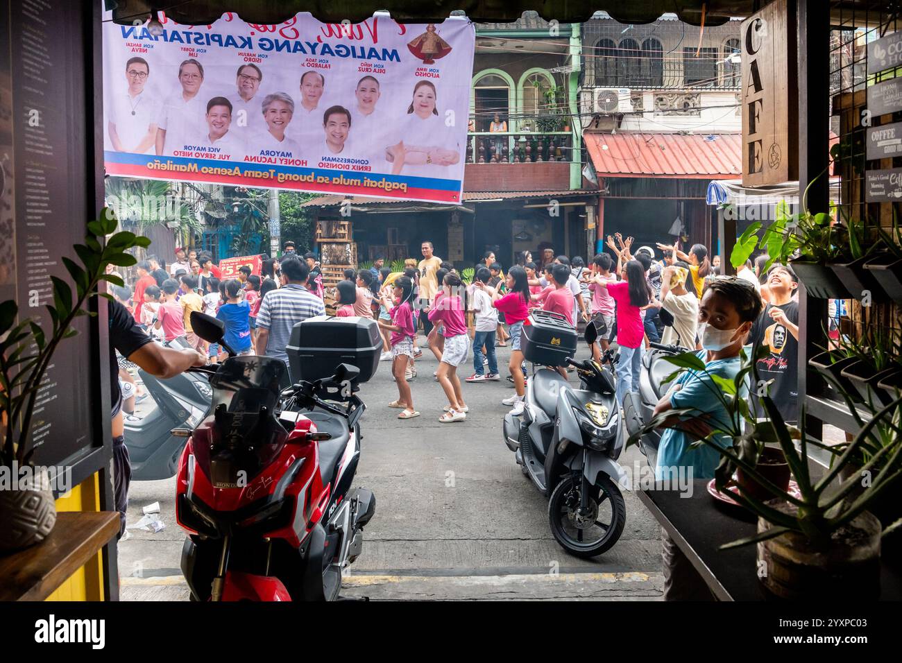 Una parata religiosa cattolica passa davanti a una casa durante una parata annuale nel distretto tondo di Manila, nelle Filippine. Foto Stock