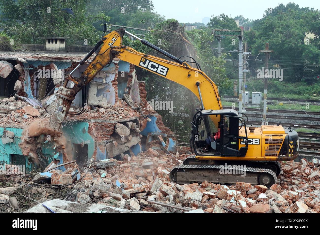 L'escavatore JCB utilizza un demolitore idraulico per demolire una casa a Chennai, Tamil Nadu, India Foto Stock