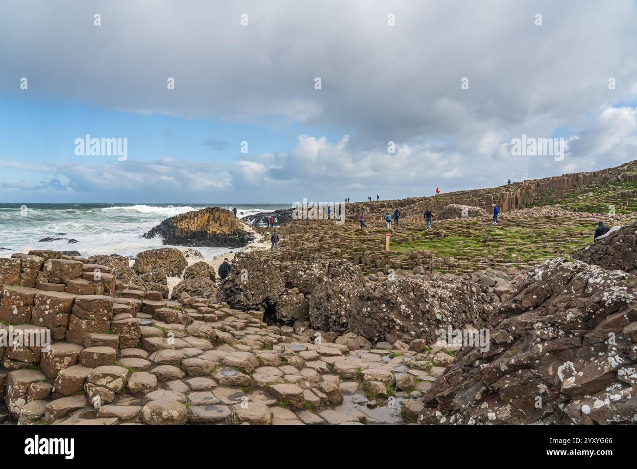 Bushmills, Irlanda del Nord - 10 settembre 2024: People on the Rocks of the Giants Causeway, un'area di pietre esagonali di basalto Foto Stock