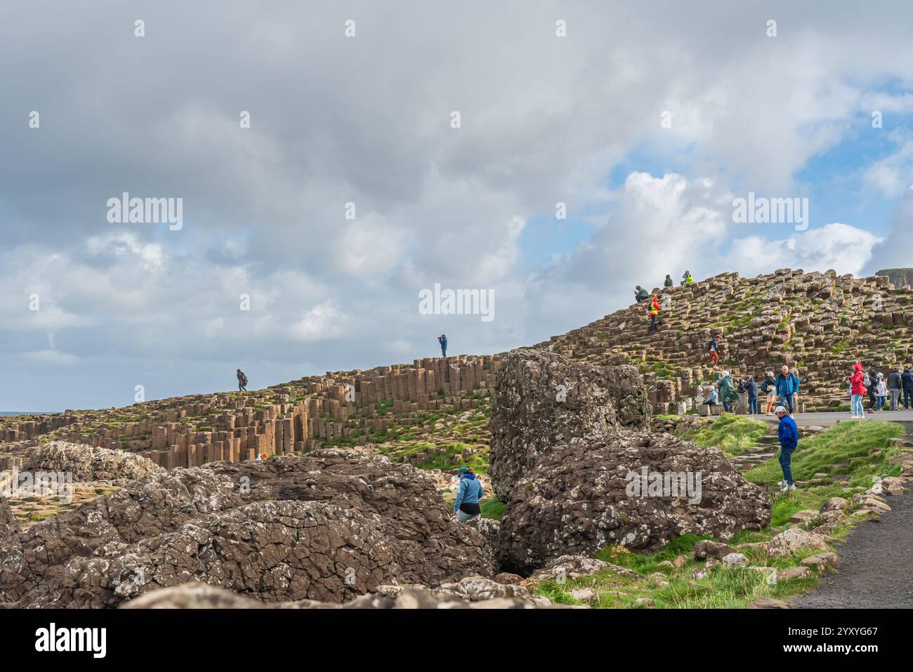 Bushmills, Irlanda del Nord - 10 settembre 2024: People on the Rocks of the Giants Causeway, un'area di pietre esagonali di basalto Foto Stock