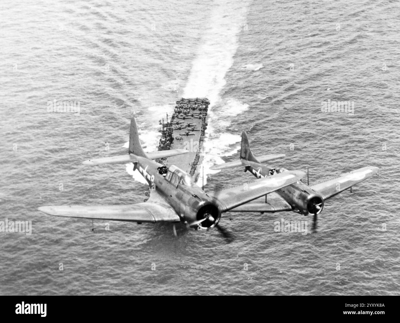 Due bombardieri Douglas SBD-5 Dauntless della US Navy dello Squadron 6 (VB-6) sorvolano la portaerei aicrcaft USS Enterprise (CV-6) il 12 novembre 1943 Foto Stock