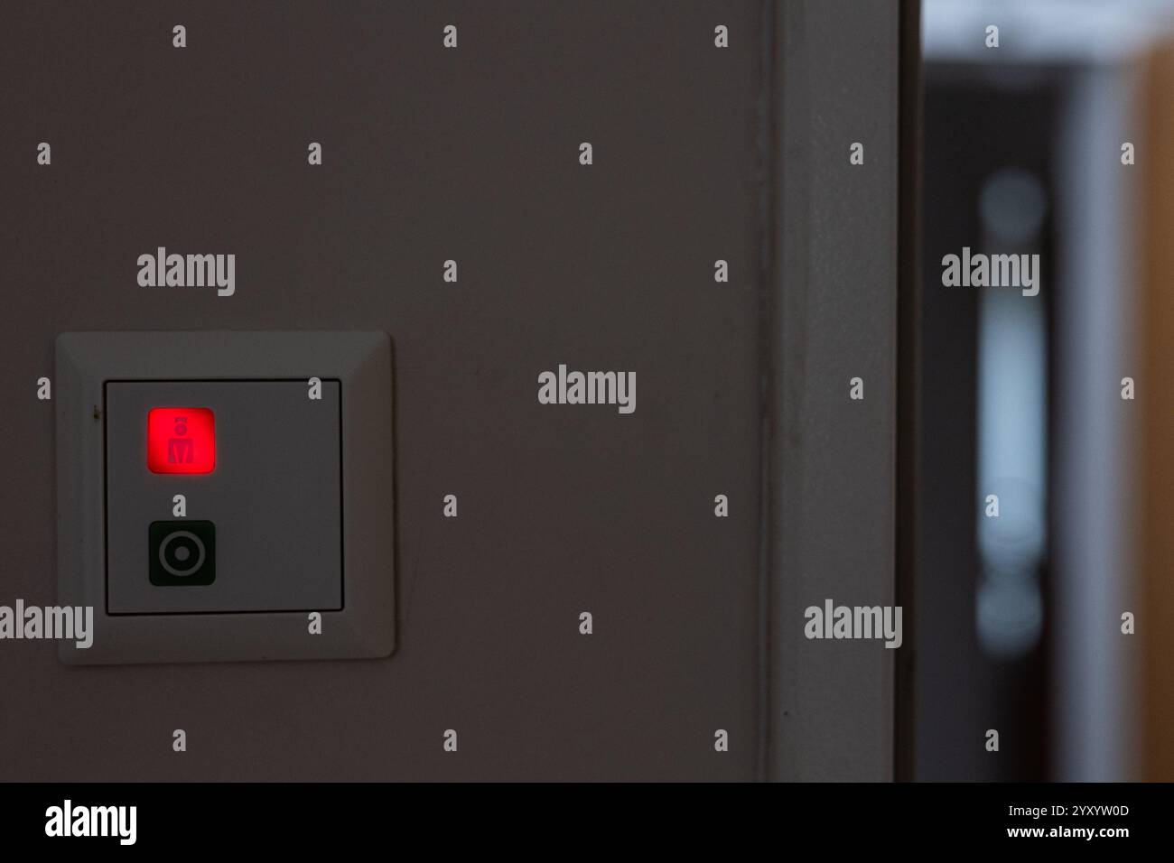 18 dicembre 2024, Brandeburgo, Brandeburgo/Havel: Pulsante illuminato rosso su un interruttore con pittogramma Pfeger nell'Ospizio di Brandeburgo. Foto: Hannes P. Albert/dpa Foto Stock
