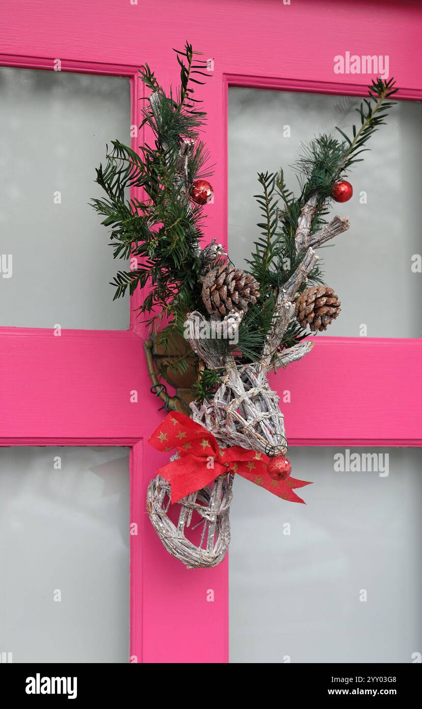 corona di natale di renna sulla porta rosa, norfolk, inghilterra Foto Stock