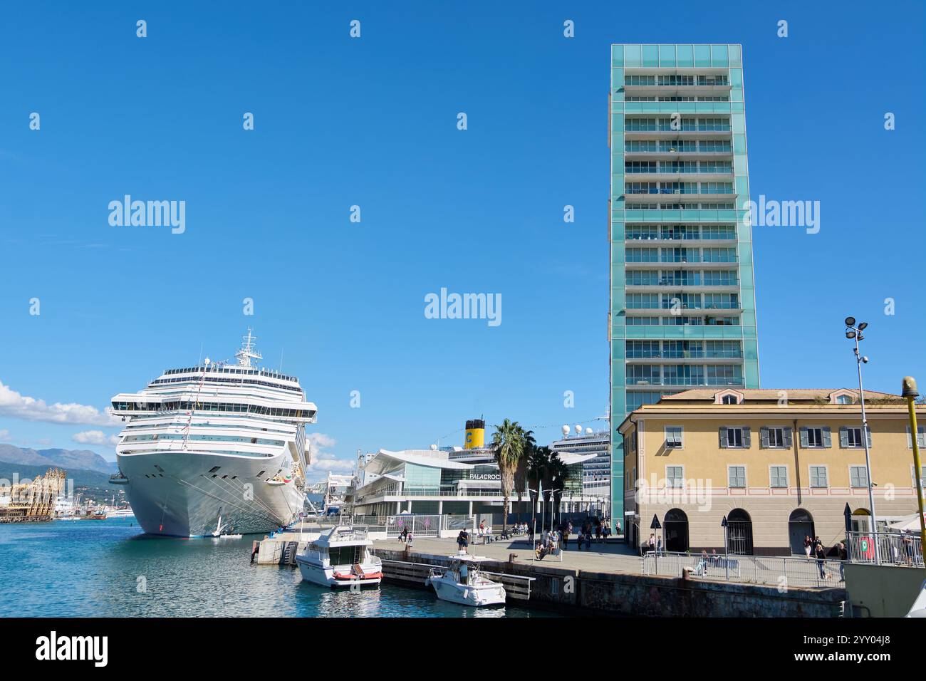 Savona, Italia - 18 dicembre 2024: Vista sul lungomare di Savona con una grande nave da crociera, edifici di uffici moderni e un molo affollato con piccole piccole dimensioni Foto Stock
