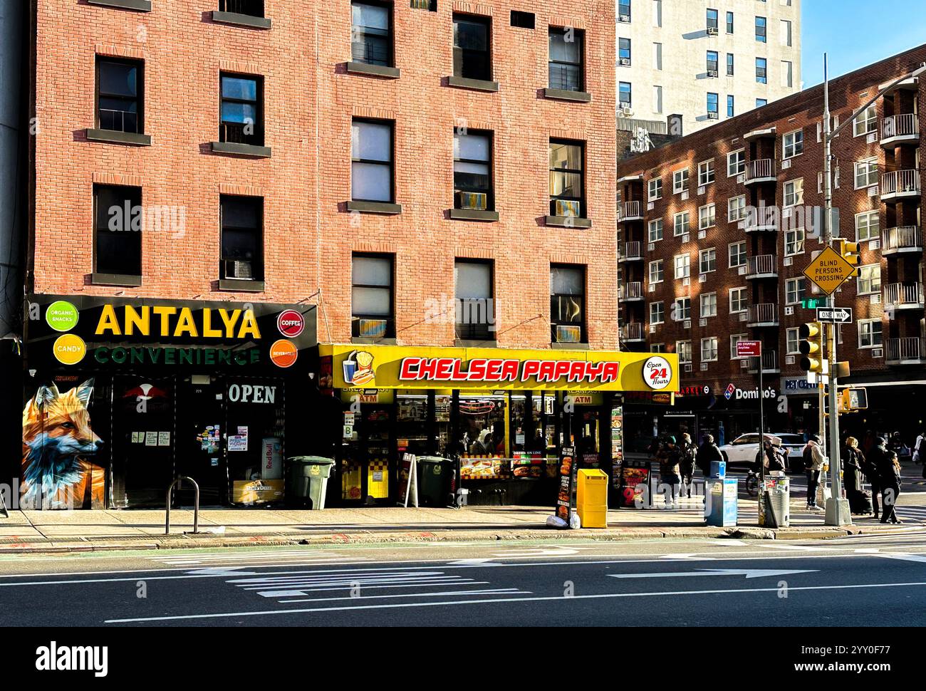 NEW YORK, NY, Stati Uniti - 13 DICEMBRE 2024: Vetrine luminose che mostrano diverse comodità e opzioni ristorative nel vivace quartiere di Chelsea Foto Stock