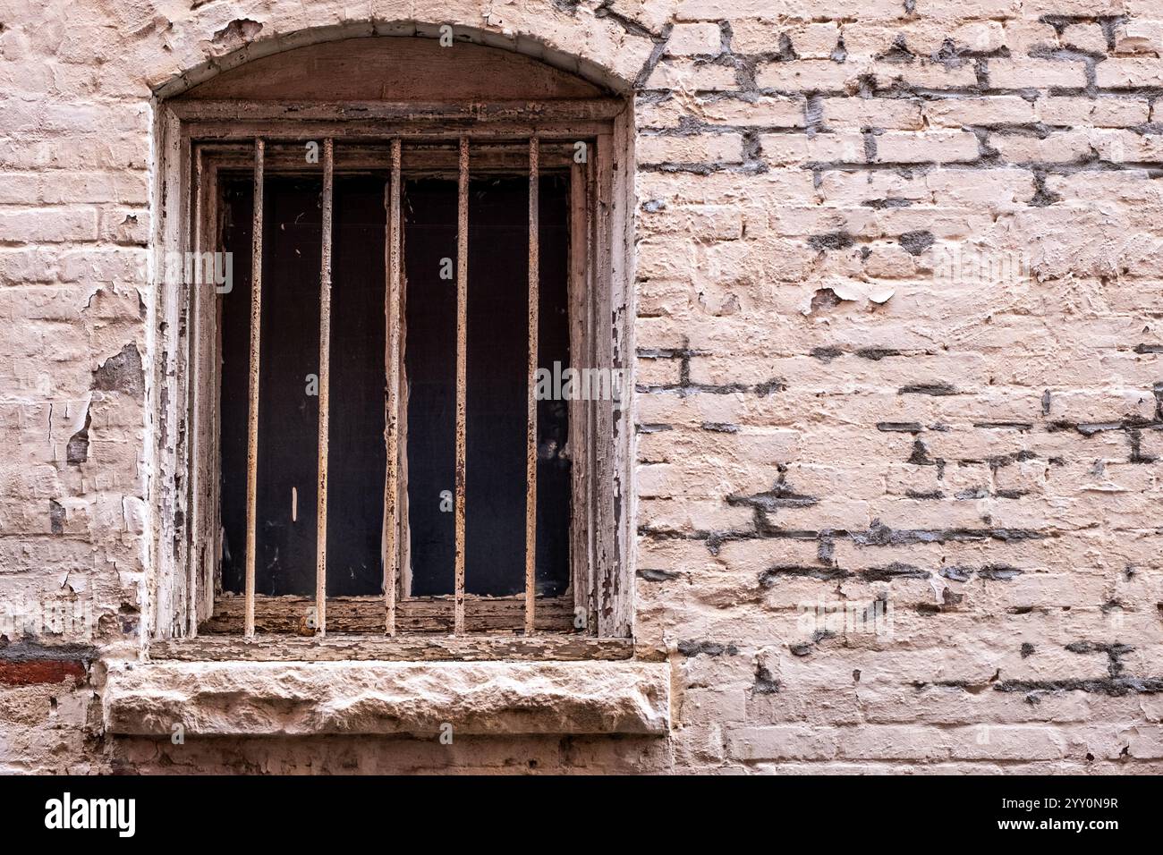 Vecchia finestra barrata e lavori in mattoni decadenti Foto Stock
