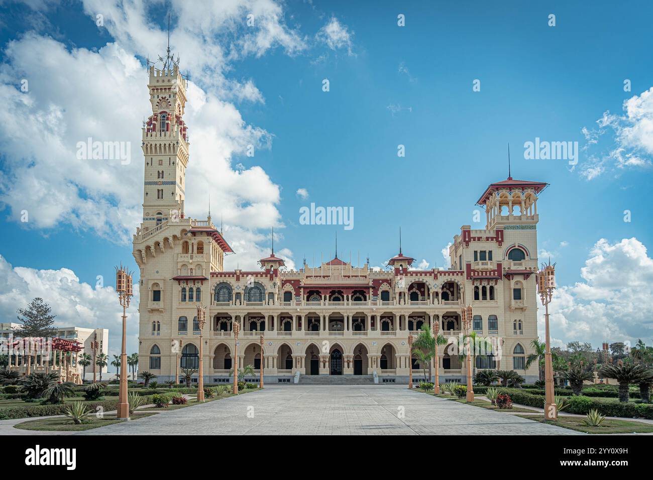 Palazzo di Montaza ad Alessandria, Egitto. Uno splendido palazzo reale dall'architettura intricata, circondato da lussureggianti giardini sotto un cielo blu luminoso. Foto Stock