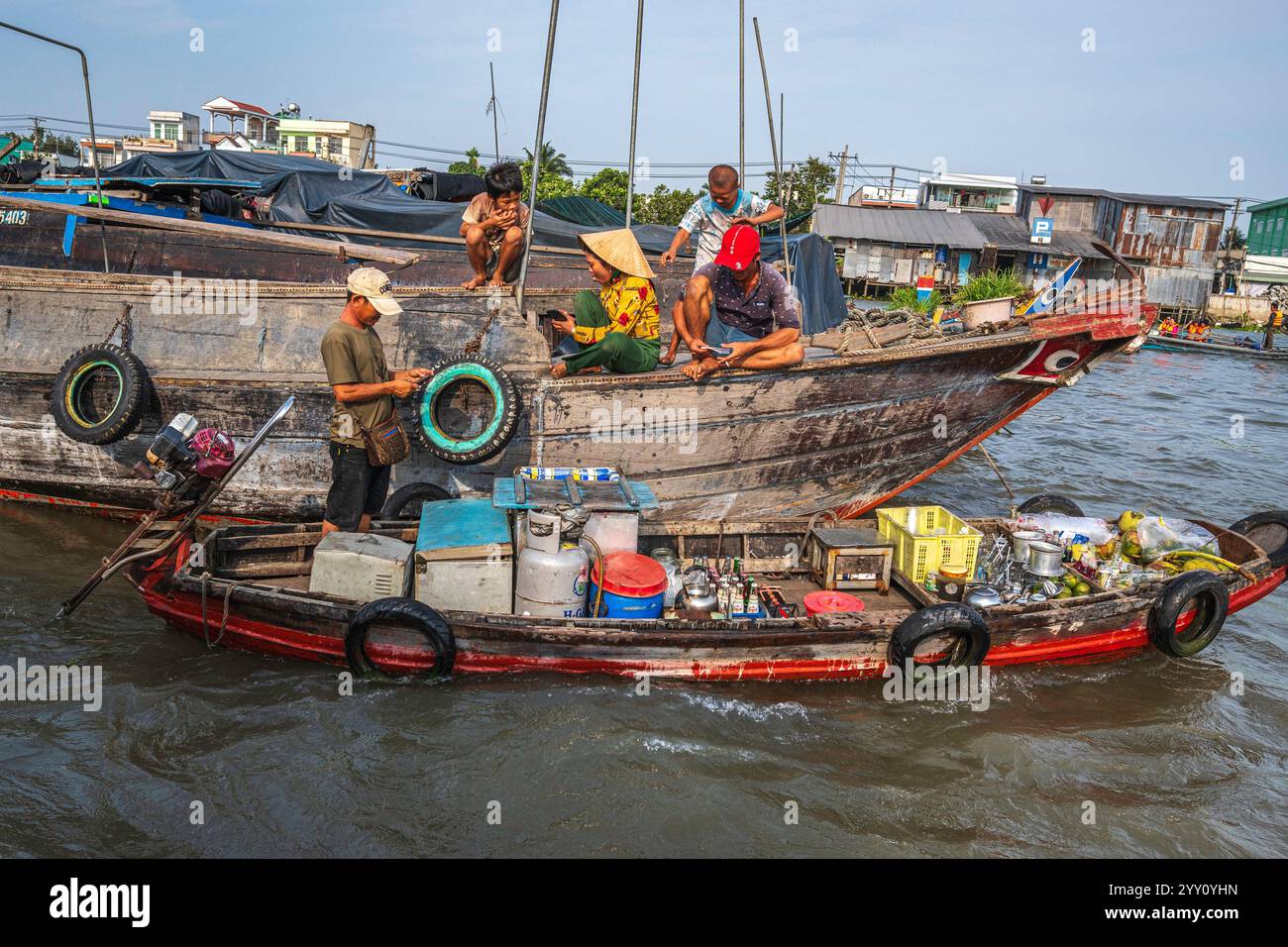 Vietnam, 2024-03-03, delta del Mekong, delta del Mekong, barca, mercato galleggiante, casa barca, venditore, merce, cappello di paglia vietnamita, sole, ombre Foto Stock