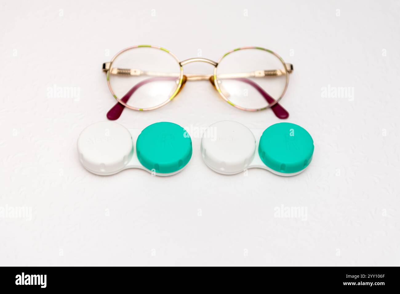occhiali e supporto per lenti a contatto su sfondo bianco, vista dall'alto Foto Stock