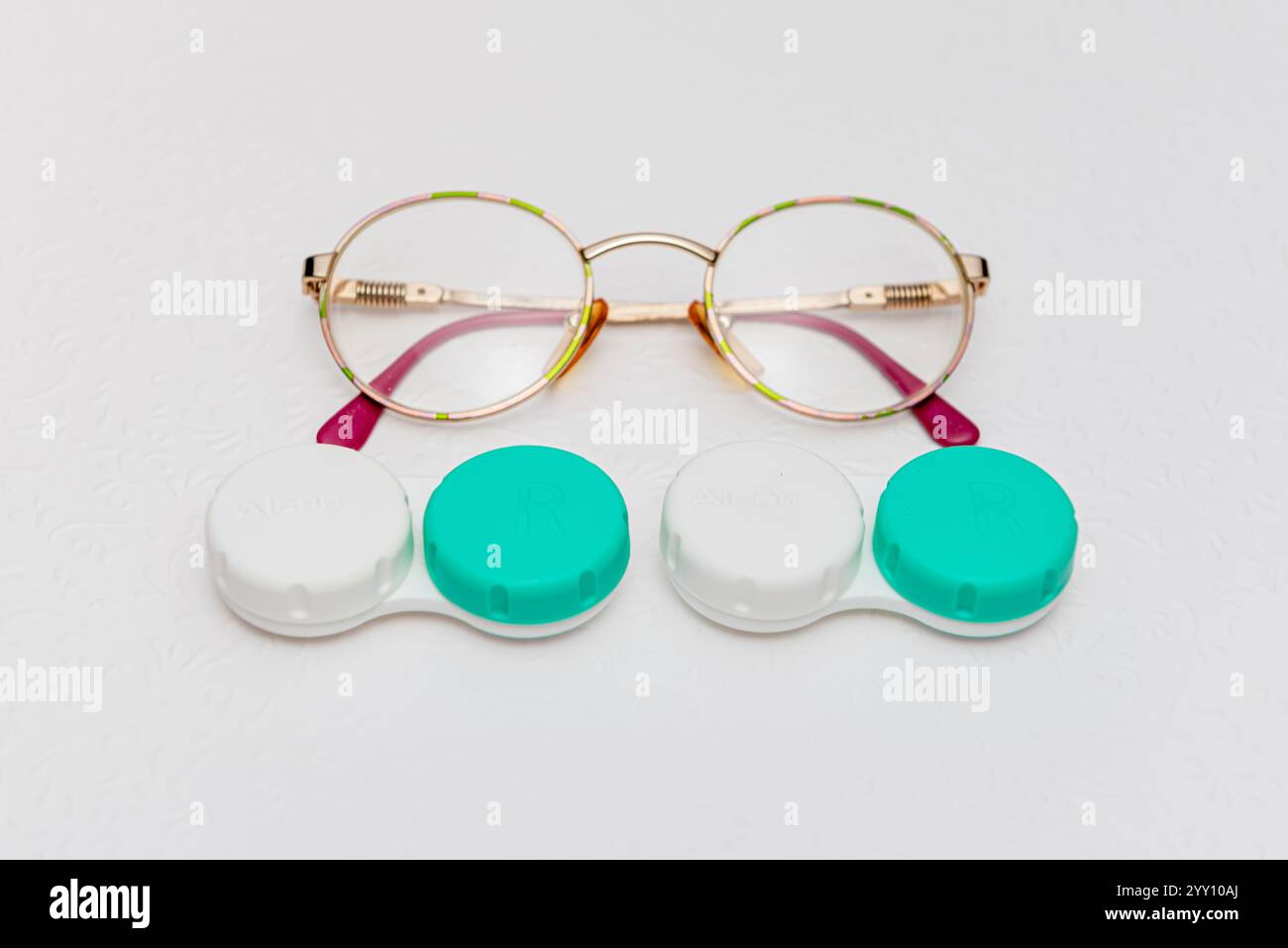 occhiali e supporto per lenti a contatto su sfondo bianco, vista dall'alto Foto Stock