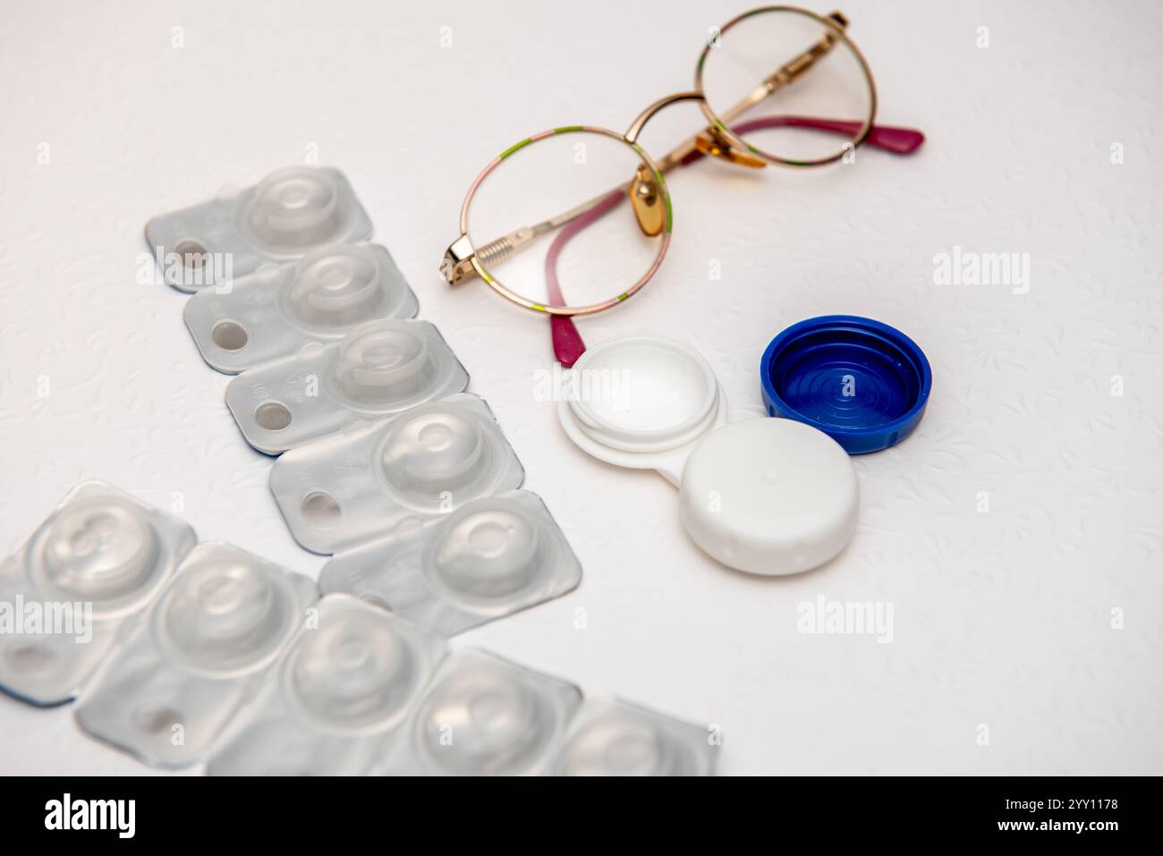 occhiali, lenti a contatto e supporto per lenti a contatto su sfondo bianco, vista dall'alto Foto Stock