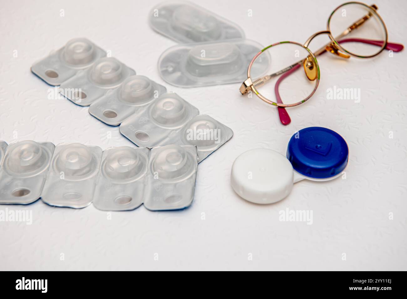 occhiali, lenti a contatto e supporto per lenti a contatto su sfondo bianco, vista dall'alto Foto Stock
