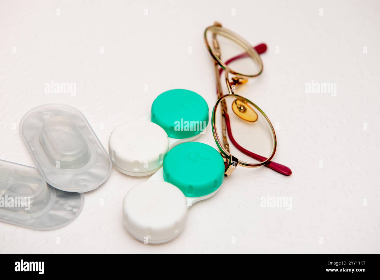 occhiali, lenti a contatto e supporto per lenti a contatto su sfondo bianco, vista dall'alto Foto Stock