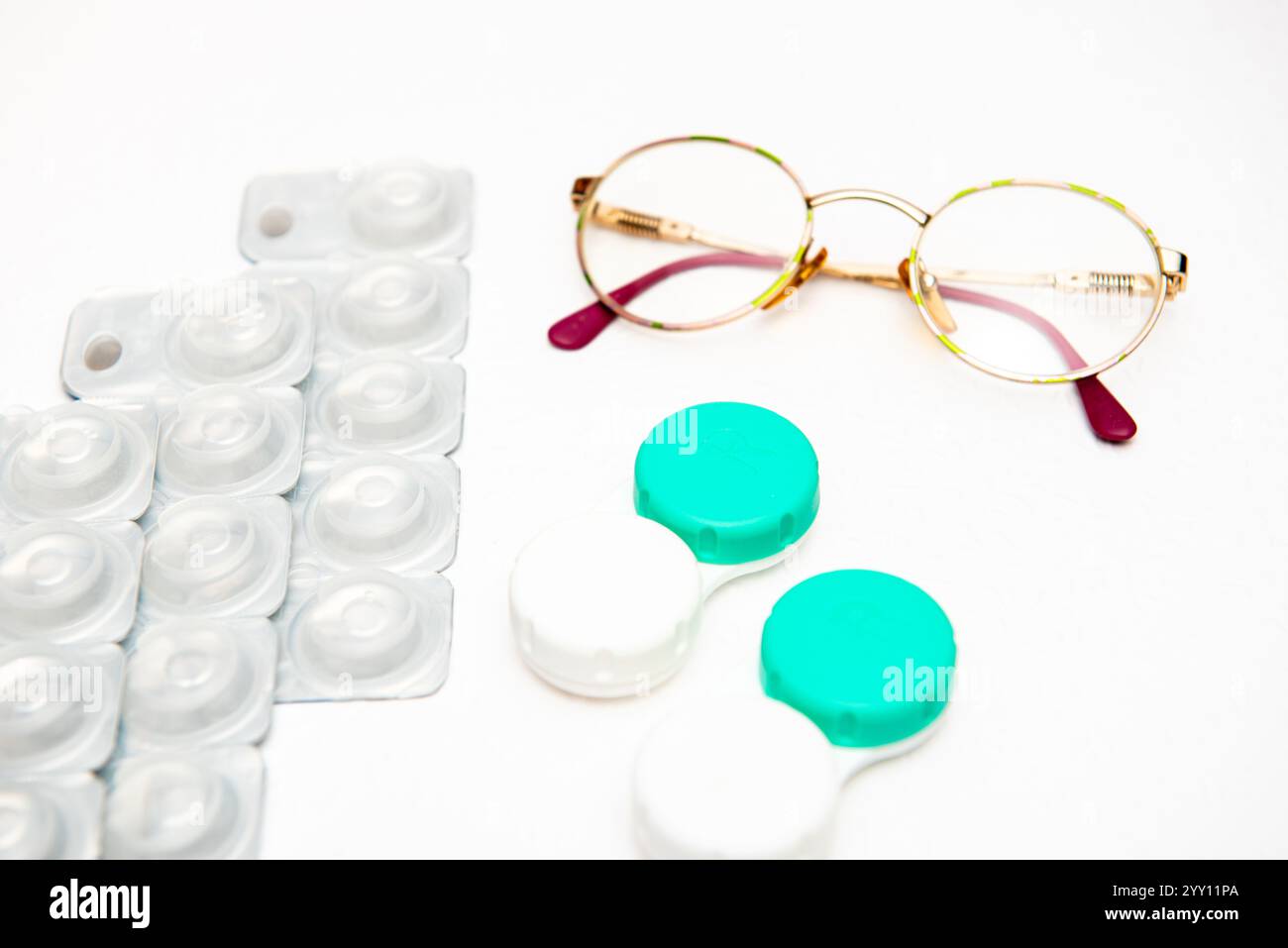 occhiali, lenti a contatto e supporto per lenti a contatto su sfondo bianco, vista dall'alto Foto Stock
