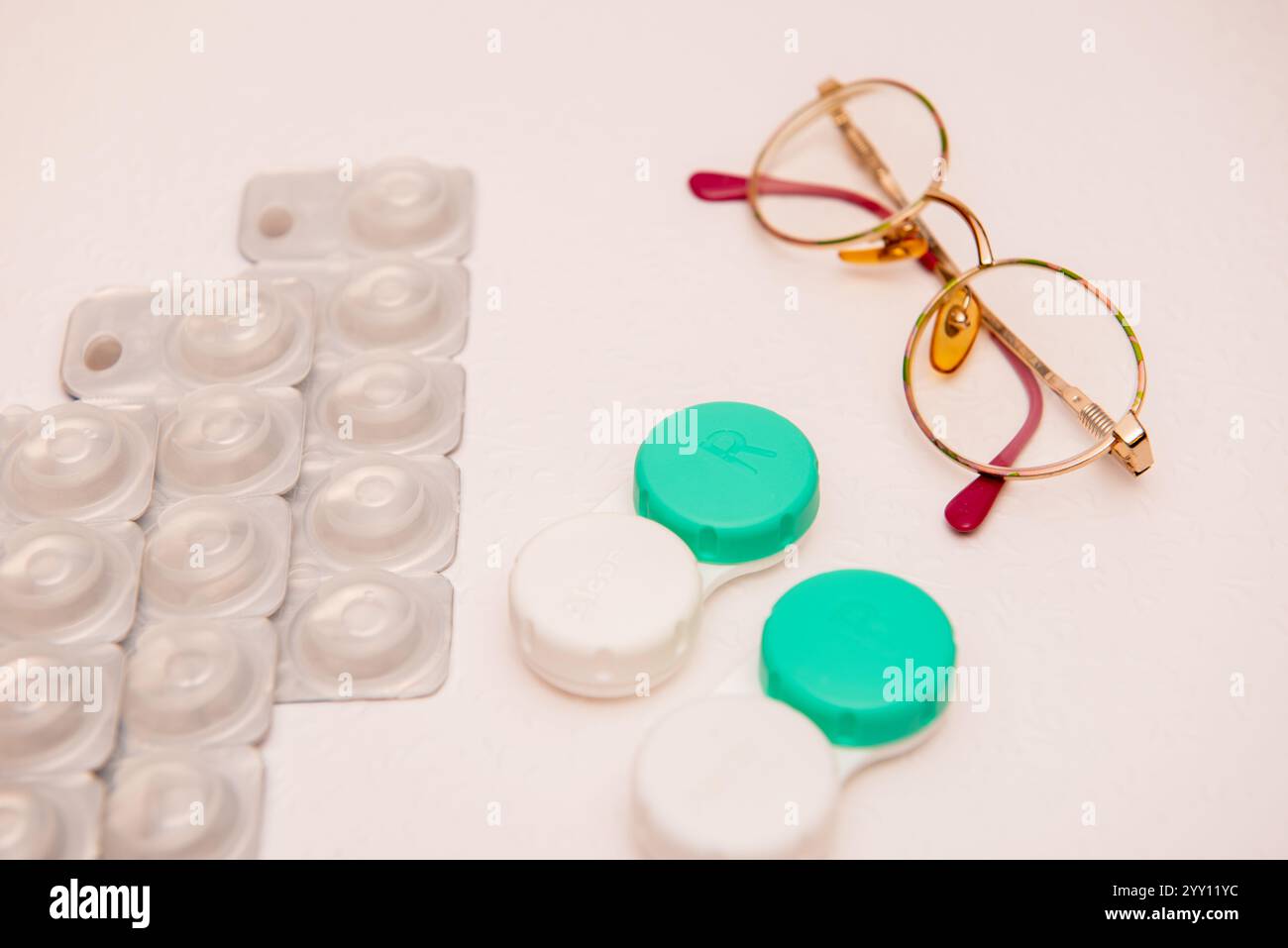 occhiali, lenti a contatto e supporto per lenti a contatto su sfondo bianco, vista dall'alto Foto Stock