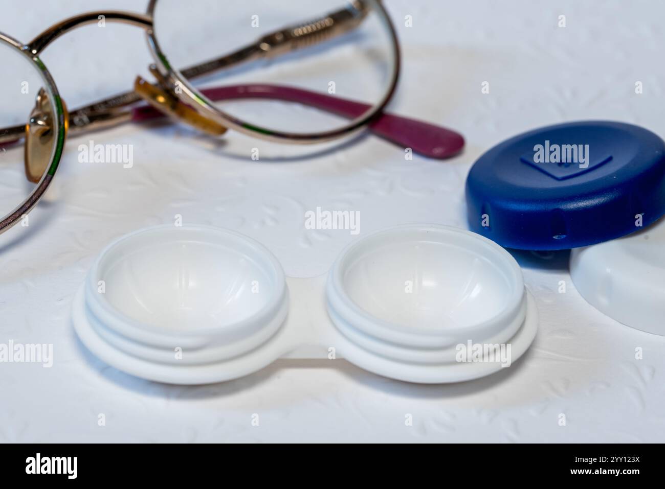 occhiali e supporto per lenti a contatto su sfondo bianco, vista dall'alto Foto Stock